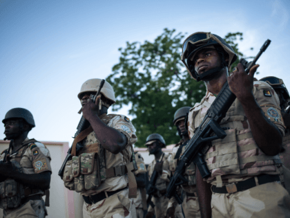 Soldiers conduct the daily flag-lowering ceremony at the Force Multinationale Mixte (FMM) base in Mora, in Cameroon's Far North Region, on September 28, 2018. - Since 2014, the Far North region of Cameroon has witnessed a conflict between the Nigerian Islamic terrorist group Boko Haram and the Cameroonian army. Approximately …