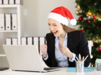 Excited office worker receiving good news on line in a laptop in christmas time
