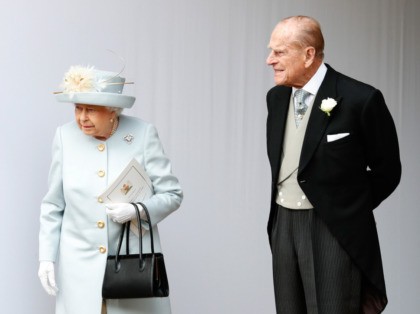 Britain's Queen Elizabeth II (L) and Britain's Prince Philip, Duke of Edinburgh (R) wait for the carriage carrying Princess Eugenie of York and her husband Jack Brooksbank to pass at the start of the procession after their wedding ceremony at St George's Chapel, Windsor Castle, in Windsor, on October 12, …
