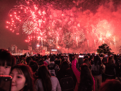 People gather as fireworks light up the city's skyline marking the New Year celebrations in Hong Kong on January 01, 2019 in Hong Kong, Hong Kong. (Photo by Billy H.C. Kwok/Getty Images)