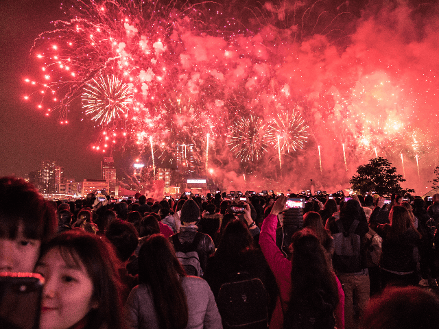 People gather as fireworks light up the city's skyline marking the New Year celebrations i