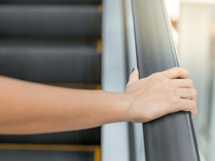 woman's hand on escalator