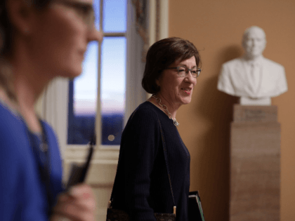 U.S. Sen. Susan Collins (R-ME) (R) walks in a hallway with aides at the U.S. Capitol Janua