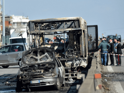 TOPSHOT - The wreckage of a school bus that was transporting some 50 children is pictured on March 20, 2019 after it was torched by the bus' driver, in San Donato Milanese, southeast of Milan. - Italian police rescued some 50 children on March 20, 2019 after their driver threatened …
