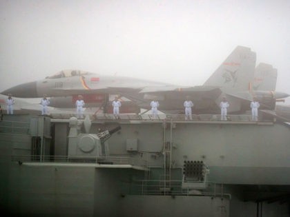 Sailors stand near fighter jets on the deck of the Chinese People's Liberation Army (PLA)