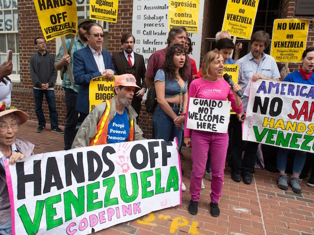 Protestors, including those with the group Code Pink, demonstrate against supporters of Venezuelan opposition leader Juan Guaido outside the Venezuelan Embassy in Washington, DC, April 25, 2019. - Activists opposed to supporters of Venezuelan opposition leader Juan Guaido and their takeover of diplomatic buildings belonging to the Venezuelan government of Nicolas Maduro have been staging a round-the-clock vigil to protect the Venezuelan Embassy in Washington DC. (Photo by SAUL LOEB / AFP) (Photo credit should read SAUL LOEB/AFP via Getty Images)