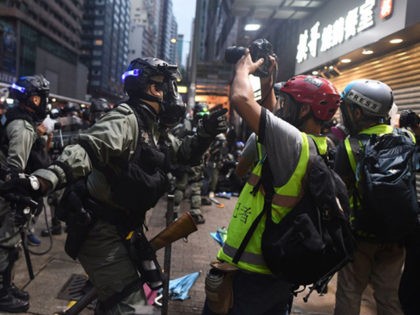 A policeman (C) tells the media to move from the area as they detain protesters during clashes in the Wanchai district in Hong Kong on October 6, 2019. - A Hong Kong judge on October 6 rejected a challenge to an emergency law criminalising protesters wearing face masks as democracy …