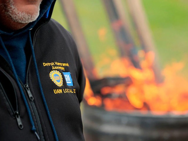 United Auto Workers (UAW) members stand around a barrel as they stay warm while striking o