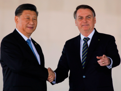 China's President Xi Jinping (L) and Brazil's President Jair Bolsonaro (L) shake hands before the 11th BRICS Summit, in Brasilia, on November 14, 2019. - Brazil's President Jair Bolsonaro walked a diplomatic tightrope, as he seeks to boost ties with Beijing and avoid upsetting key ally Donald Trump, on the …