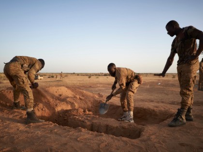 A group of soldiers of the Burkina Faso Army dig foxholes for sentinels in a temporary base set in the region of Soum in northern Burkina Faso on November 12, 2019. (Photo by MICHELE CATTANI / AFP) (Photo by MICHELE CATTANI/AFP via Getty Images)