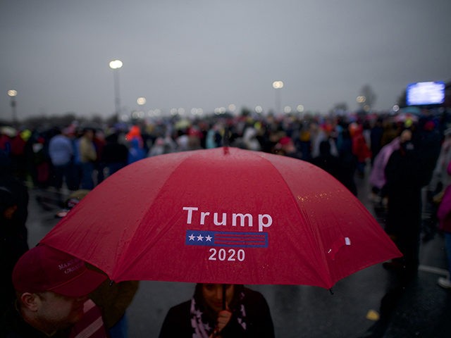 HERSHEY, PA - DECEMBER 10: Supporters holding a "Trump 2020" umbrella wait in the rain bef