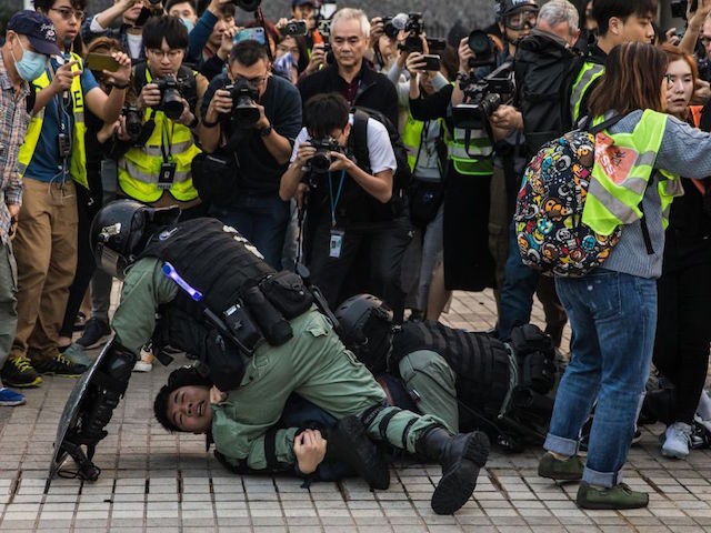 TOPSHOT - Police detain a man during a rally in Hong Kong on December 22, 2019 to show sup