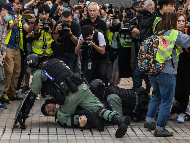 TOPSHOT - Police detain a man during a rally in Hong Kong on December 22, 2019 to show support for the Uighur minority in China. - Hong Kong riot police broke up a solidarity rally for China's Uighurs on December 22 -- with one officer drawing a pistol -- as the city's pro-democracy movement likened their plight to that of the oppressed Muslim minority. (Photo by Dale DE LA REY / AFP) (Photo by DALE DE LA REY/AFP via Getty Images)