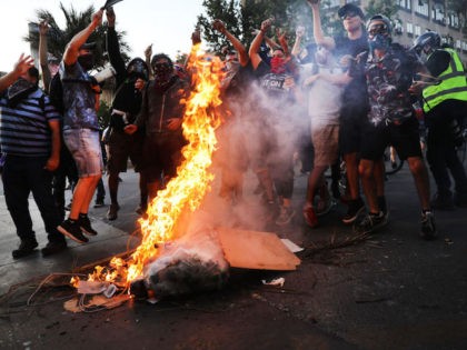SANTIAGO, CHILE - DECEMBER 05: Protesters burn a barricade in downtown Santiago as demonst