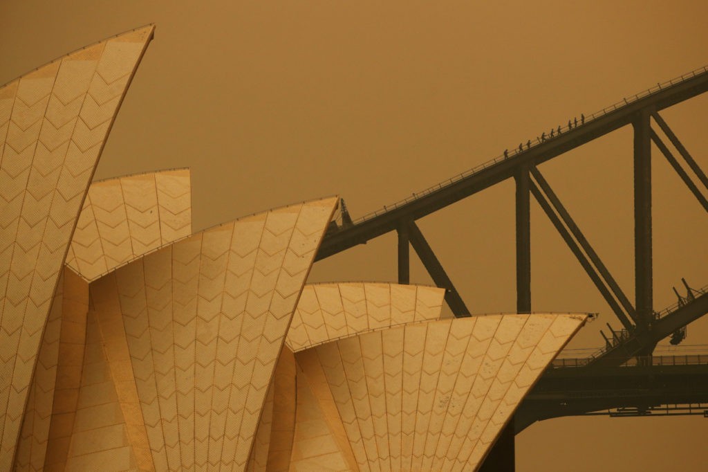 People climb the Sydney Harbour Bridge during a guided tour on December 6, 2019 in Sydney, Australia. Most of NSW remains under severe or very high fire danger warnings as more than 50 fires continue to burn across the state. Six people have died and 577 homes have been lost since the start of the bushfire season, with 420 homes destroyed in the past month alone. (Cameron Spencer/Getty Images)