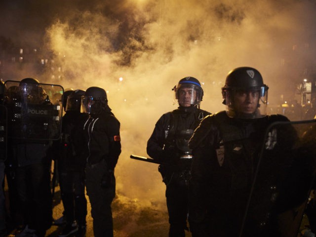 PARIS, FRANCE - DECEMBER 17: French Riot Police look towards protestors through clouds of