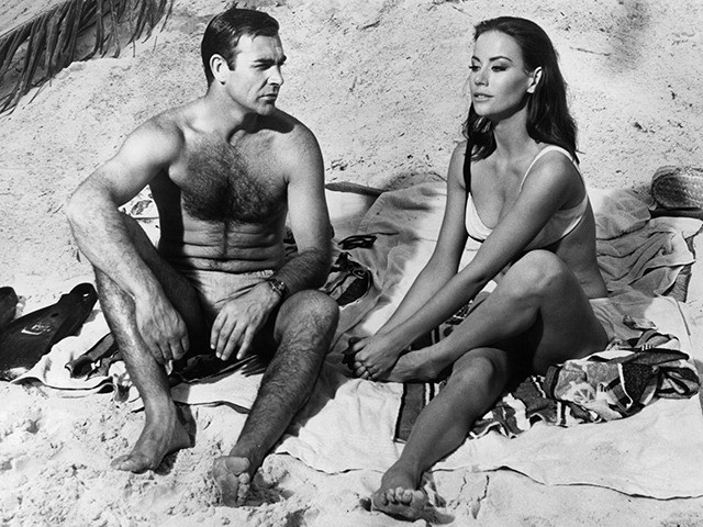 Sean Connery watches Claudine Auger clutch her foot after having stepped on a poisonous se