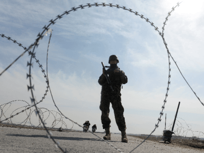 An Afghan National Army (ANA) soldier stands guard outside the Bagram prison gate, some 50