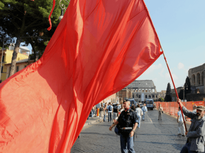 A man waves a red flag during a protest by Italian leftwing opposition parties -- Refoundation Communist, Italian Communists, Greens and Left Democratic -- against the economic policies of the Berlusconi government in Rome on October 11, 2008 AFP PHOTO / ALBERTO PIZZOLI (Photo credit should read ALBERTO PIZZOLI/AFP via …