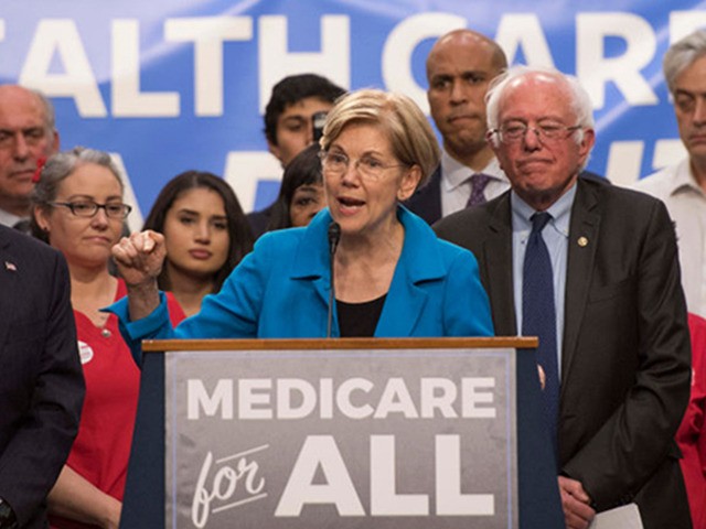 US Senator Elizabeth Warren (C), Democrat from Massachusetts, speaks with US Senator Bernie Sanders (2nd R), Independent from Vermont, as they discusses Medicare for All legislation on Capitol Hill in Washington, DC, on September 13, 2017.