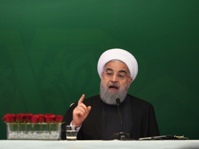 Iranian President Hassan Rouhani (R) delivers a speech to Muslims leaders and scholars as