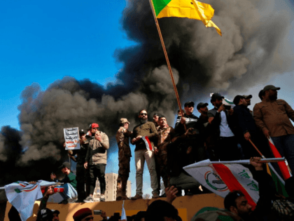 Protesters burn property in front of the U.S. embassy compound, in Baghdad, Iraq, Tuesday, Dec. 31, 2019. Dozens of angry Iraqi Shiite militia supporters broke into the U.S. Embassy compound in Baghdad on Tuesday after smashing a main door and setting fire to a reception area, prompting tear gas and …