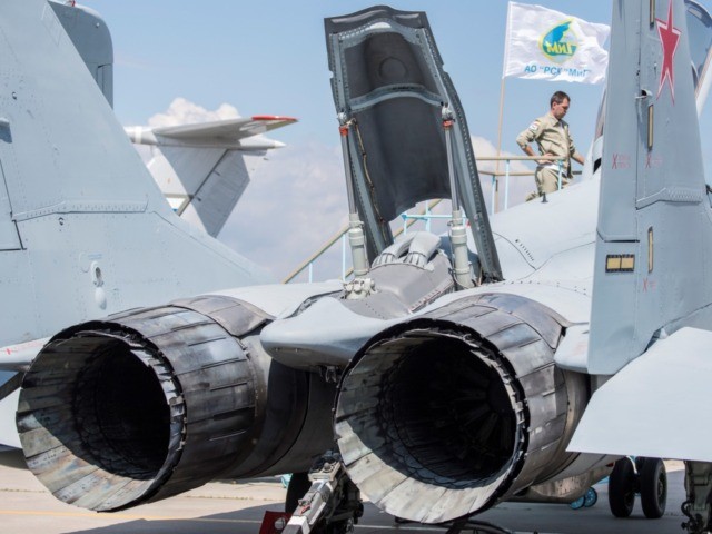 A Russian pilot stands next to his Mig 29 military plane on display at the annual air show