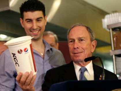 New York City Mayor Michael Bloomberg looks at a 64oz cup, as Lucky's Cafe owner Greg Anagnostopoulos, left, stands behind him, during a news conference at the cafe in New York, Tuesday, March 12, 2013. New Yorkers were still free to gulp from huge sugary drinks Tuesday, after a judge …