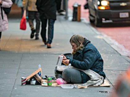 NEW YORK, NY - DECEMBER 10: A homeless person eats on a side walk near Time Square on Dece