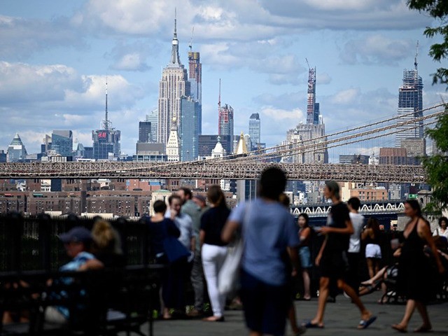 Tourists enjoy the sunny weekend in front of the Brooklyn Bridge and the skyline of Manhattan on August 24, 2019 in New York City. (Photo by Johannes EISELE / AFP) (Photo credit should read JOHANNES EISELE/AFP via Getty Images)