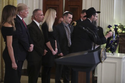 WASHINGTON, DC - DECEMBER 6: (AFP-OUT) Rabbi Avraham Friedman, right, holds the candle to light the menorah next to President Donald Trump, first lady Melania Trump, Andy Pollack (3rd L), Julie Phillips, center, and Hunter Pollack, second right, during a Hanukkah reception in the East Room of the White House …