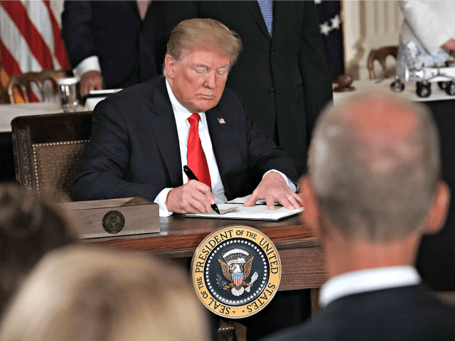 WASHINGTON, DC - JUNE 18: U.S. President Donald Trump signs an executive order during a meeting of the National Space Council at the East Room of the White House June 18, 2018 in Washington, DC. President Trump signed an executive order to establish the Space Force, an independent and co-equal …