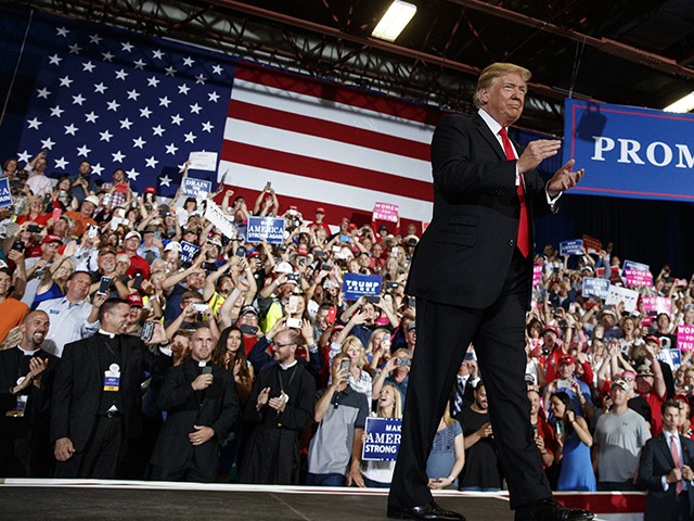 In this July 5, 2018, photo, President Donald Trump turns to the cheering crowd as he arrives for a rally at the Four Seasons Arena at Montana ExpoPark, in Great Falls, Mont. A Roman Catholic bishop in Montana has criticized four priests who attended President Donald Trump's rally in Great Falls last week for wearing their black clerical garb while prominently seated in the front row directly behind the president. The priests are seen in the audience wearing VIP badges. (AP Photo/Carolyn Kaster)