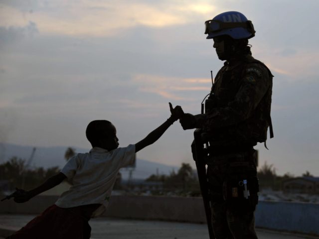 A Brazilian soldier with the MINUSTAH force greets a boy at a shantytown in Port-au-Prince on March 2, 2013. Brazil began the process of reducing its peace-keeping forces operating under the MINUSTAH mandate from 1910 to 1450 men, the same number that was there before the deadly 2010 earthquake that …