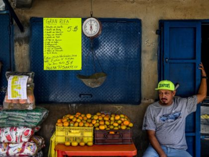 A fruit seller waits for customerat the market of El valle neighborhood in Caracas on November 19, 2019. - Venezuela's President Nicolas Maduro has been forced to loosen exchange controls and the prevailing prices during the 20 years of Chavism, due to lack of liquidity, collapse of the oil production …