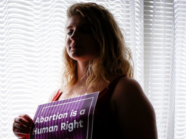 In this Aug. 5, 2019, photo, Beth Vial, who didn’t learn she was pregnant until 26 weeks after chronic medical conditions masked her symptoms, poses for a portrait at her home in Portland, Ore. Vial was beyond the point when nearly every abortion clinic in the country would perform the …