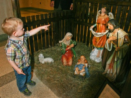 Samuel Voran, 19 months, points to a Christmas nativity scene installed Tuesday, Dec. 3, 2013 at the Florida Capitol rotunda in Tallahassee, Fla. A private group, helped by a conservative law firm, set up the first nativity scene in decades inside the rotunda. (AP Photo/Phil Sears)
