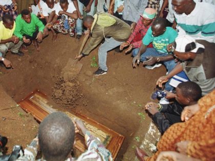 CONAKRY, GUINEA: People surround a grave as the casket of one of the two young Guineans found frozen to death in the undercarriage well of a Belgian Airbus last Monday, is buried, 08 August 1999 in the Cameroon districk cemetery of Conakry. The bodies of Yaguine Koita, 14, and Fode …