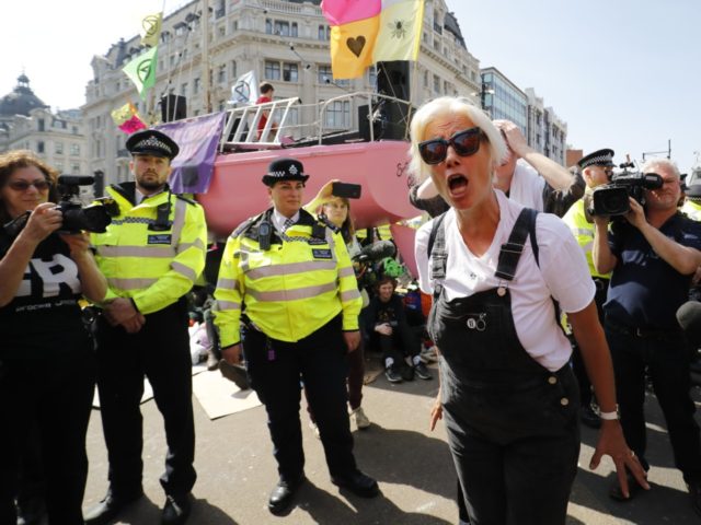 British actress Emma Thompson (C) gestures as police surround the pink boat being used as a stage by climate change activists as they occupy the road junction at Oxford Circus in central London on April 19, 2019 during the fifth day of an environmental protest by the Extinction Rebellion group. …