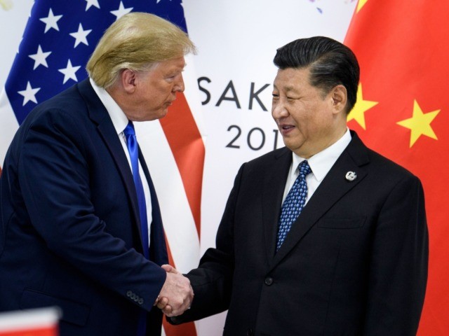In this file photo taken on June 28, 2019, China's President Xi Jinping (R) shakes hands w