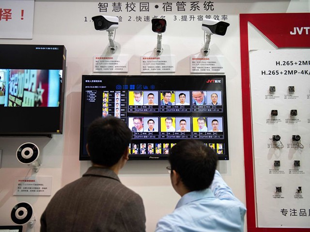 Visitors look at AI (Artificial Inteligence) security cameras with facial recognition technology at the 14th China International Exhibition on Public Safety and Security at the China International Exhibition Center in Beijing on October 24, 2018. (Photo by NICOLAS ASFOURI / AFP) (Photo credit should read NICOLAS ASFOURI/AFP via Getty Images)