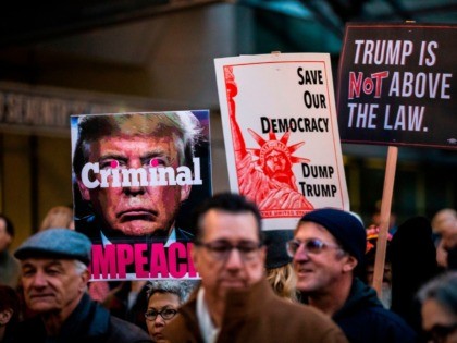 Protesters hold signs during a demonstration in part of a national impeachment rally, at t