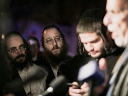 Orthodox Jewish people listen to N.Y. state Assemblyman Dov Hikind speak in Monsey, N.Y., Sunday, Dec. 29, 2019, following a stabbing late Saturday during a Hanukkah celebration. A man attacked the celebration at a rabbi's home north of New York City late Saturday, stabbing and wounding several people before fleeing …