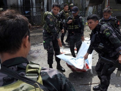 Philippine security personnel carry a body bag containing the remains of a blast victim af