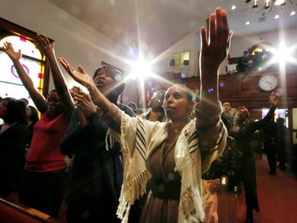 In this Feb. 27, 2011 photo, Salome Desta of Ethiopia and other members of the congregation worship during a church service at Pentacostal Tabernacle in Cambridge, Mass. The small historic black church, sitting between MIT and Harvard, has attracted students from Asia, Africa, Europe and Latin America to rejuvenate a …
