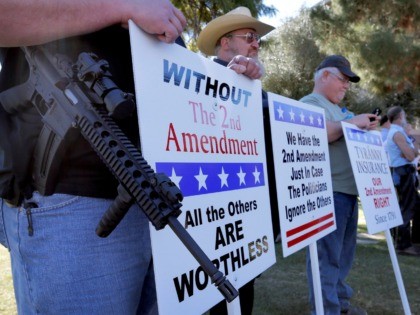 Gun rights supporters stand outside the Capitol Sat, Jan. 19, 2013 in Phoenix during a Guns Across America rally. The nationwide rally was in support of the 2nd Amendment and called for no new gun laws. (AP Photo/Matt York)