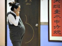 A pregnant woman speaks on the phone in Beijing Getty