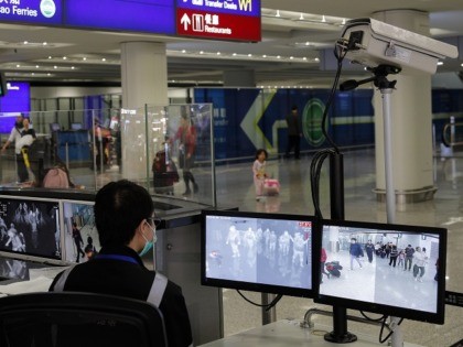 FILE - In this Jan. 4, 2020, file photo, a health surveillance officer monitors passengers arriving at the Hong Kong International airport in Hong Kong. A preliminary investigation into viral pneumonia illnesses sickening dozens of people in and around China has identified the possible cause as a new type of …