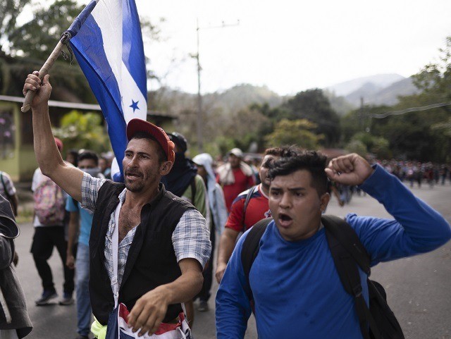 Migrants carrying Honduran flags walk along a highway in hopes of reaching the distant United States, near Agua Caliente, Guatemala, Thursday, Jan. 16, 2020, on the border with Honduras. Hundreds of Honduran migrants started walking and hitching rides Wednesday from the city of San Pedro Sula, in a bid to …