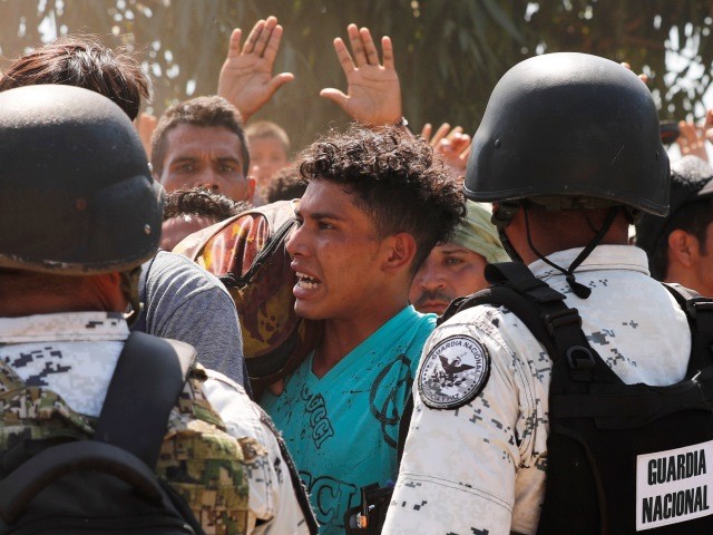 Central American migrants who crossed the Suchiate River from Guatemala to Mexico are stopped by Mexican National Guard on the riverbank near Ciudad Hidalgo, Mexico, Monday, Jan. 20, 2020. Hundreds of Central American migrants hoping to reach United States marooned in Guatemala crossed en masse through a river leading to Mexico in an attempt to convince authorities there to allow them passage through the country. (AP Photo/Marco Ugarte)